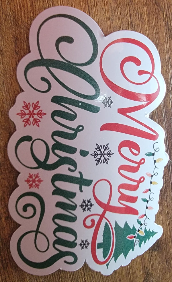 Christmas-themed sticker with 'Merry Christmas' text on a wooden surface
