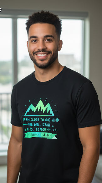 Man wearing a black t-shirt with green mountain design and text.