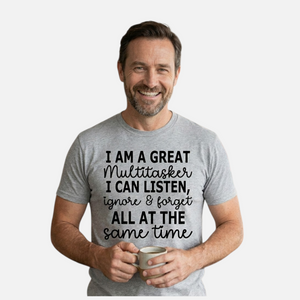 Man wearing a gray t-shirt with humorous text design, holding a mug.