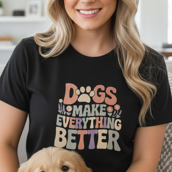 Woman wearing a black t-shirt with a dog-themed design, sitting with a golden puppy.