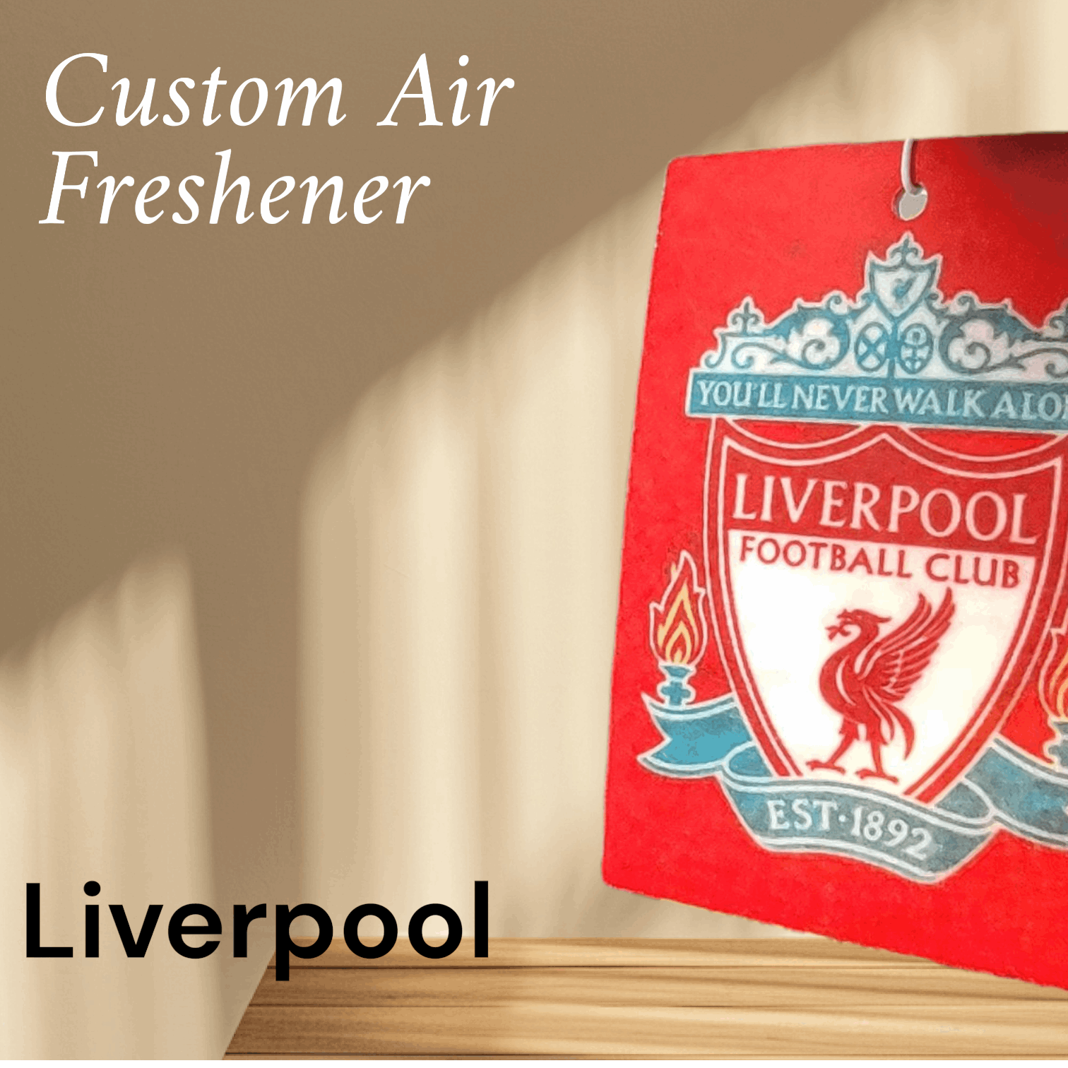Red air freshener with Liverpool Football Club logo on a beige wall.