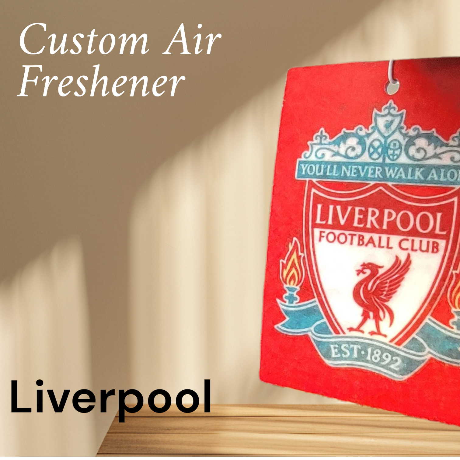 Red air freshener with Liverpool Football Club logo on a beige wall.